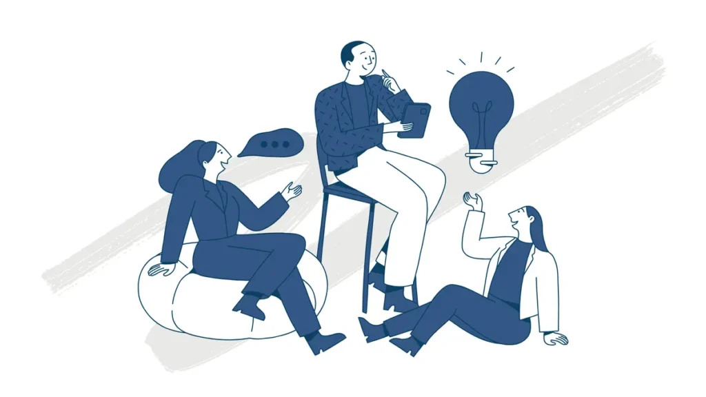 group of people brainstorming ideas around a table with a glowing light bulb